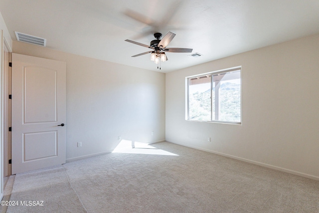 spare room featuring light carpet and ceiling fan