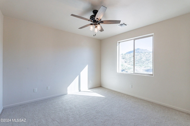 empty room featuring light colored carpet and ceiling fan