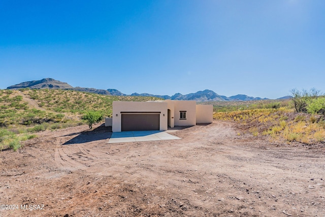 pueblo-style home featuring a mountain view and a garage