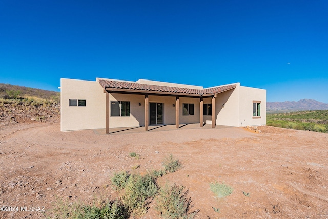 back of property featuring a patio area and a mountain view