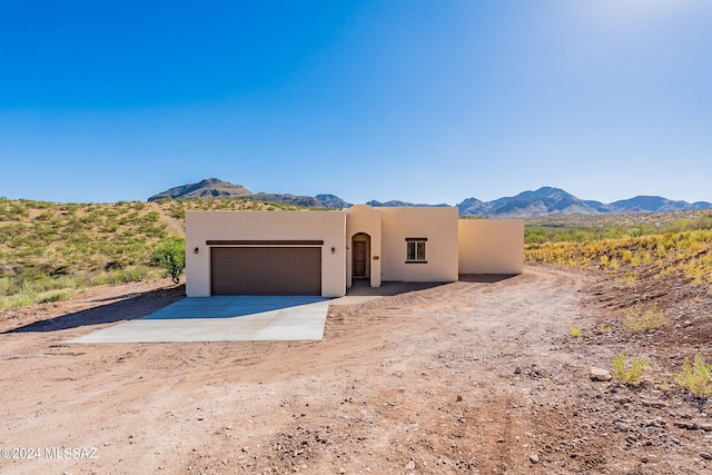 pueblo-style house with a mountain view and a garage