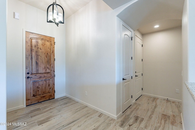 entryway with light wood-type flooring and an inviting chandelier