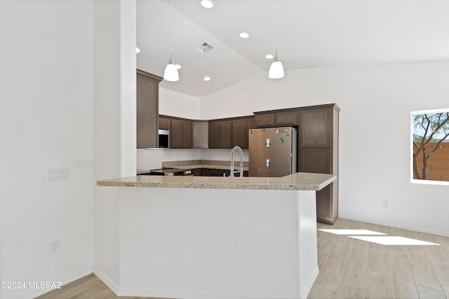 kitchen with kitchen peninsula, hanging light fixtures, stainless steel appliances, and light hardwood / wood-style floors