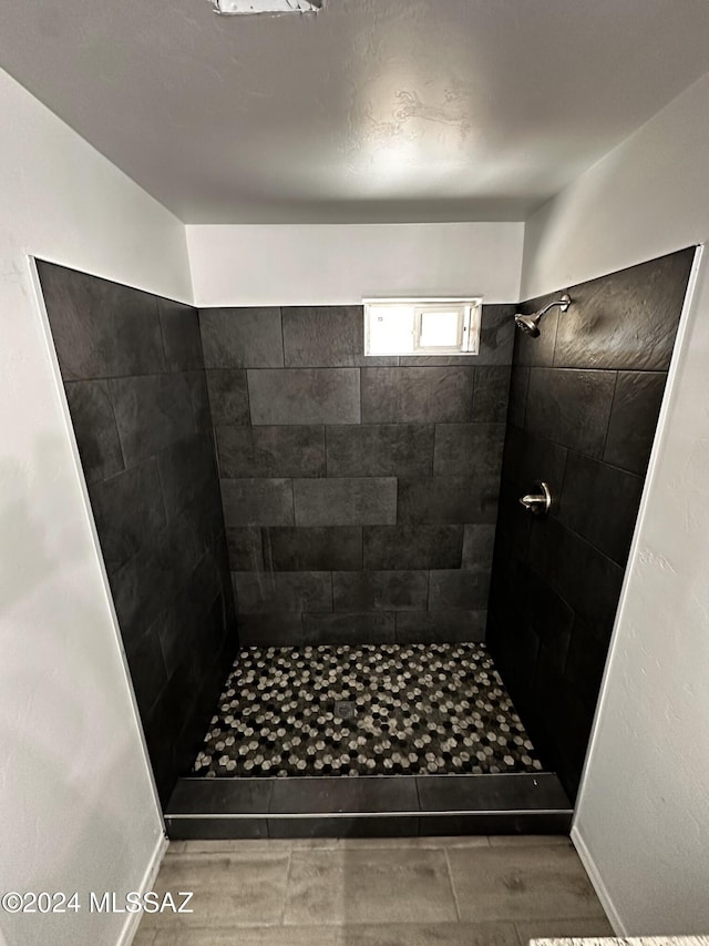 bathroom featuring tile patterned flooring and tiled shower