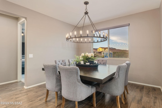 dining area with hardwood / wood-style floors and a chandelier