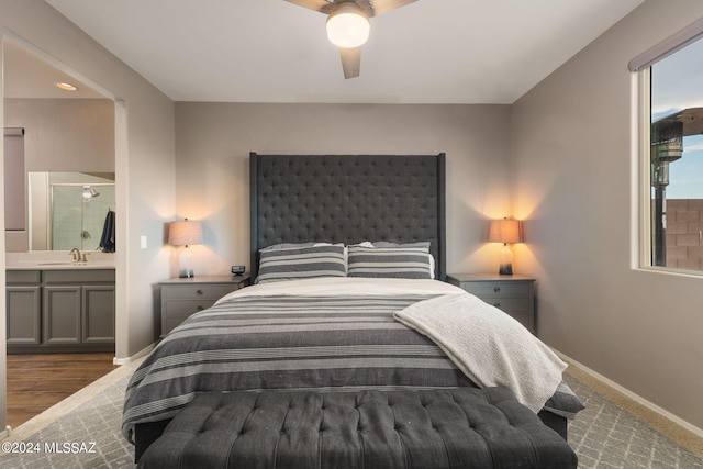 bedroom with dark hardwood / wood-style floors, sink, ceiling fan, and ensuite bathroom