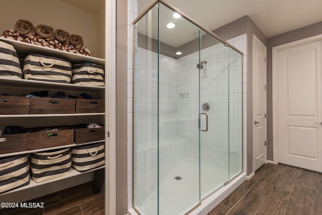 bathroom with wood-type flooring and walk in shower