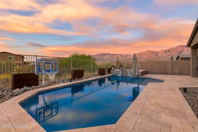 pool at dusk featuring a mountain view