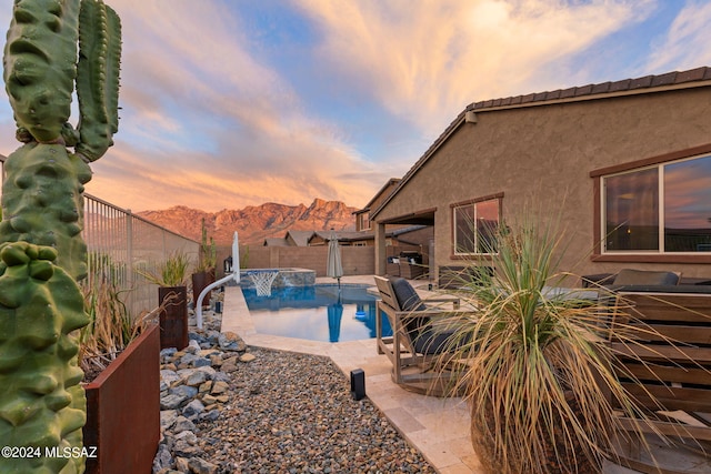 pool at dusk with a patio area