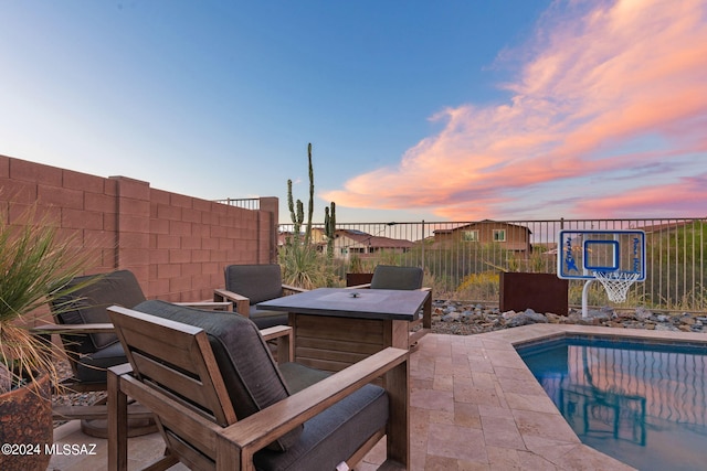 patio terrace at dusk with a fenced in pool