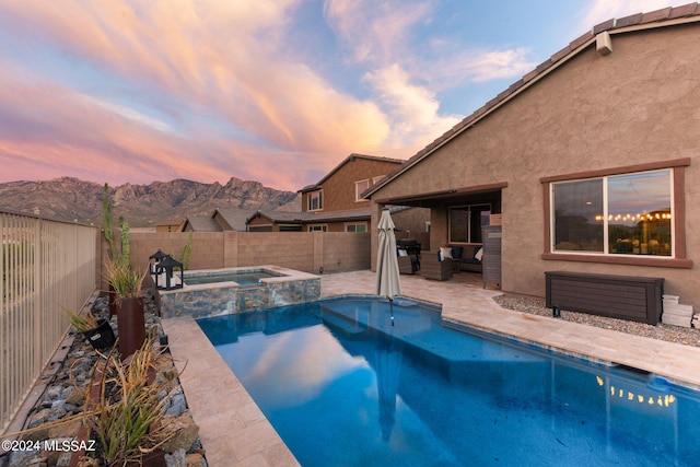 pool at dusk with a patio, an in ground hot tub, and outdoor lounge area