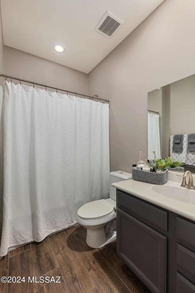 bathroom with wood-type flooring, vanity, and toilet