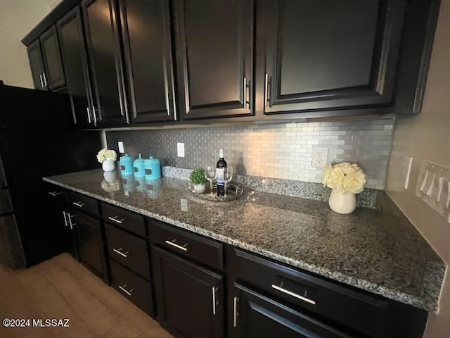 kitchen featuring light hardwood / wood-style floors, light stone counters, and tasteful backsplash