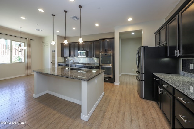 kitchen featuring decorative backsplash, sink, appliances with stainless steel finishes, and light wood-type flooring