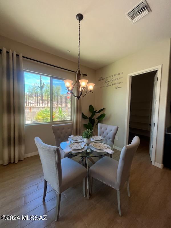 dining space with a chandelier and wood-type flooring