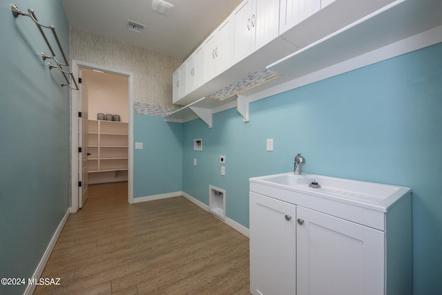 washroom featuring hookup for an electric dryer, light wood-type flooring, cabinets, and hookup for a washing machine