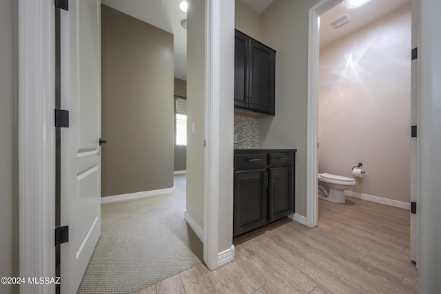 bathroom featuring backsplash, wood-type flooring, toilet, and vanity