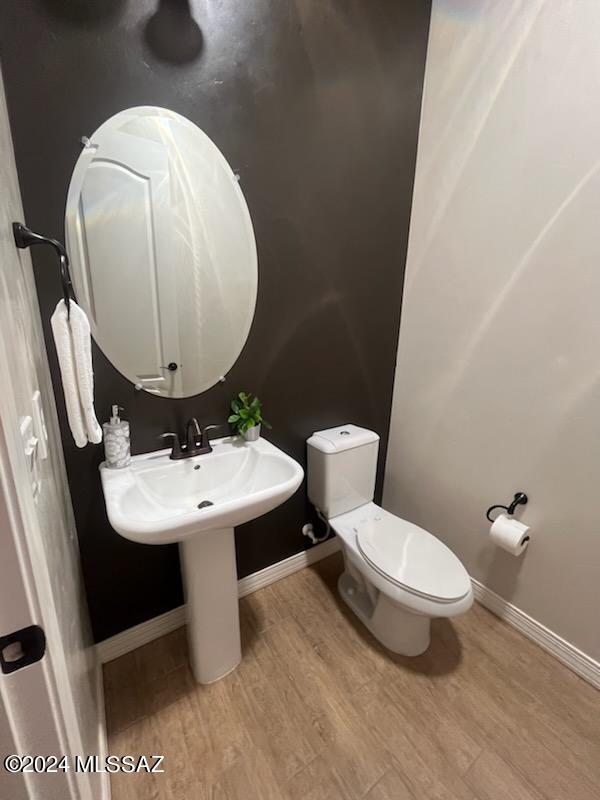 bathroom featuring toilet and wood-type flooring