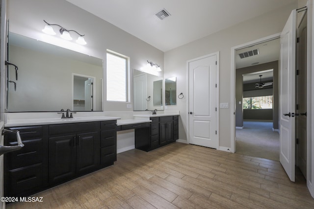 bathroom with double vanity, hardwood / wood-style floors, and ceiling fan