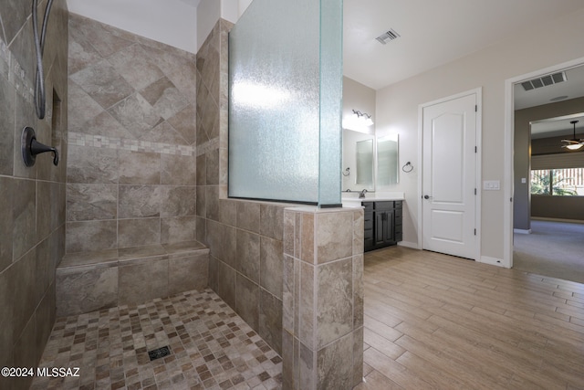 bathroom with vanity, ceiling fan, wood-type flooring, and tiled shower