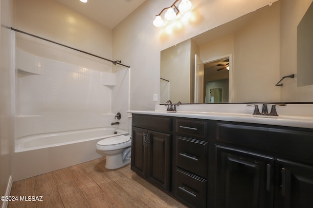 full bathroom with hardwood / wood-style flooring, double sink vanity, ceiling fan, tub / shower combination, and toilet