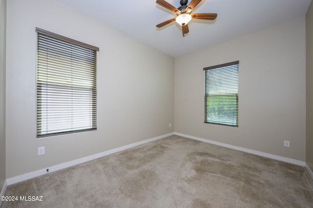 unfurnished room with light colored carpet and ceiling fan