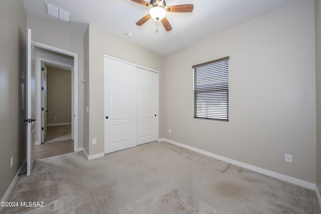 unfurnished bedroom with a closet, ceiling fan, and light colored carpet