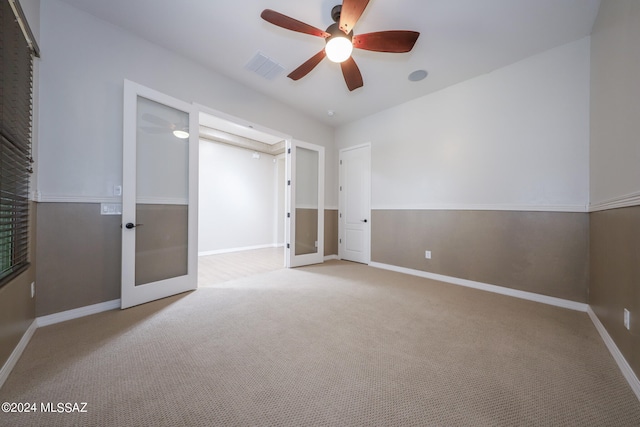 carpeted empty room featuring ceiling fan and french doors