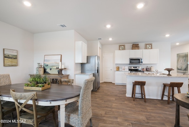 dining room featuring sink and dark wood-type flooring