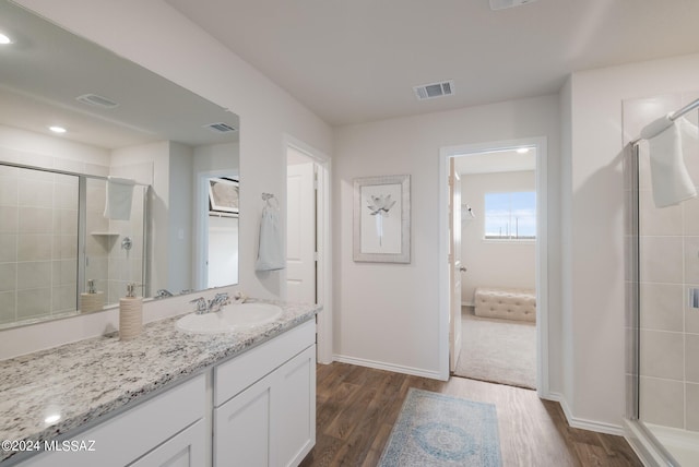 bathroom featuring a shower with door, hardwood / wood-style floors, and vanity