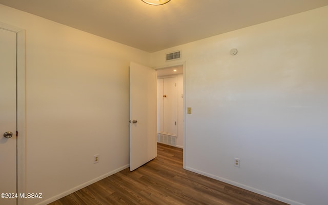 unfurnished room with dark wood-type flooring