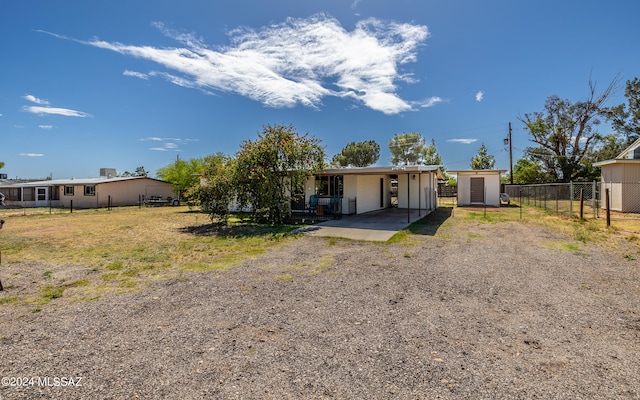 view of front of home with a front lawn and a storage shed