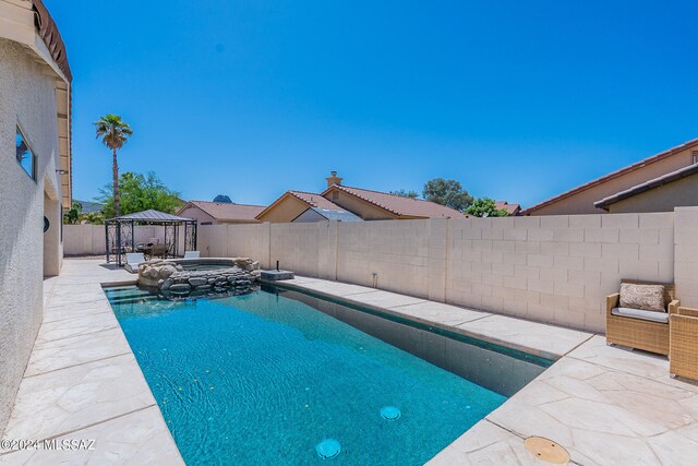 view of swimming pool with a patio, an outdoor hot tub, and a gazebo