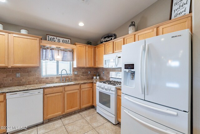 kitchen featuring light stone countertops, white appliances, tasteful backsplash, sink, and light tile floors