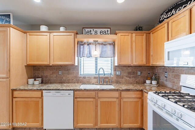 kitchen with backsplash, light brown cabinetry, white appliances, and sink