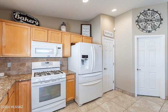 kitchen with stone countertops, white appliances, tasteful backsplash, and light tile floors