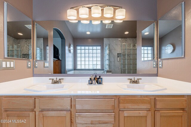 bathroom with double sink, a shower with shower door, and oversized vanity