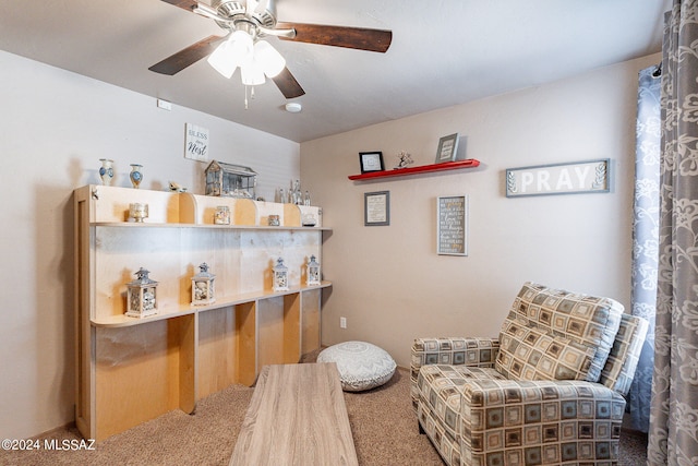 living area with ceiling fan and carpet