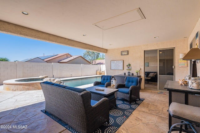 view of patio / terrace with a swimming pool with hot tub