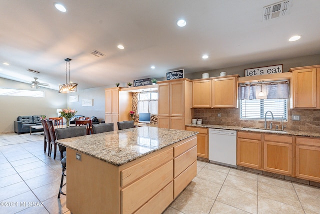 kitchen featuring backsplash, sink, a kitchen island, dishwasher, and ceiling fan