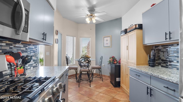 kitchen with gray cabinets, tasteful backsplash, ceiling fan, and light tile floors