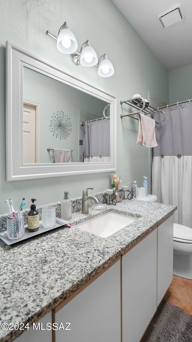 bathroom featuring vanity, tile floors, and toilet