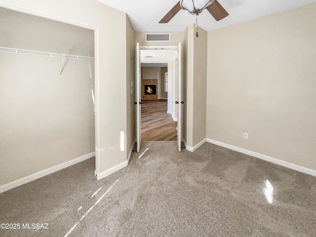 unfurnished bedroom with carpet floors, ceiling fan, and a closet