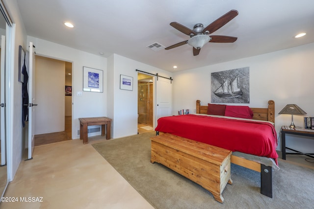 bedroom featuring ensuite bath, ceiling fan, carpet, and a barn door