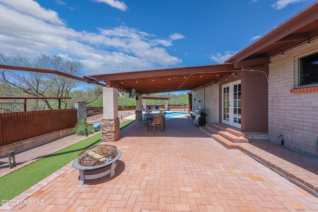 view of patio / terrace with french doors and a fire pit