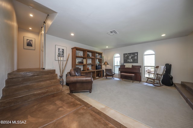 sitting room featuring carpet floors and a barn door