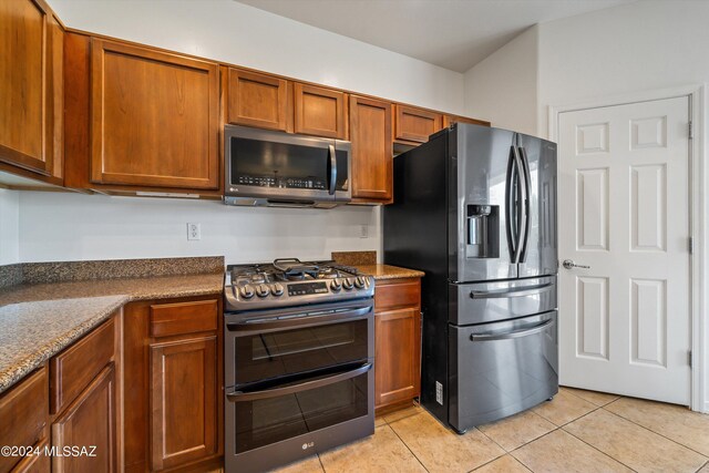 kitchen featuring black appliances, light tile patterned floors, and sink