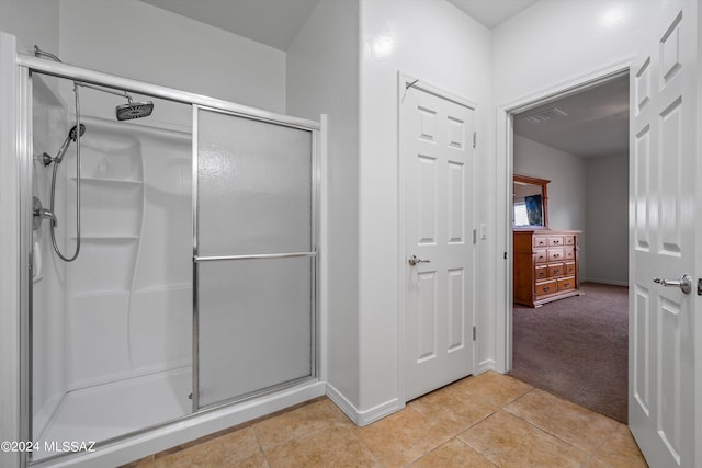 bathroom featuring tile patterned floors and a shower with shower door