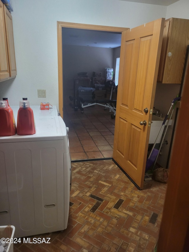 interior space with light countertops, brick floor, and washing machine and dryer