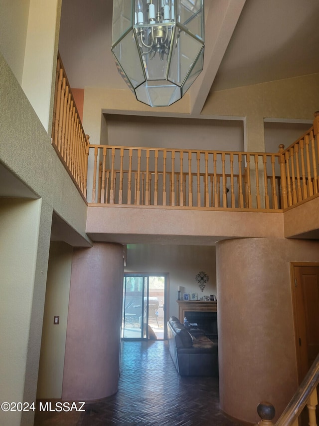 hall with a towering ceiling and an inviting chandelier